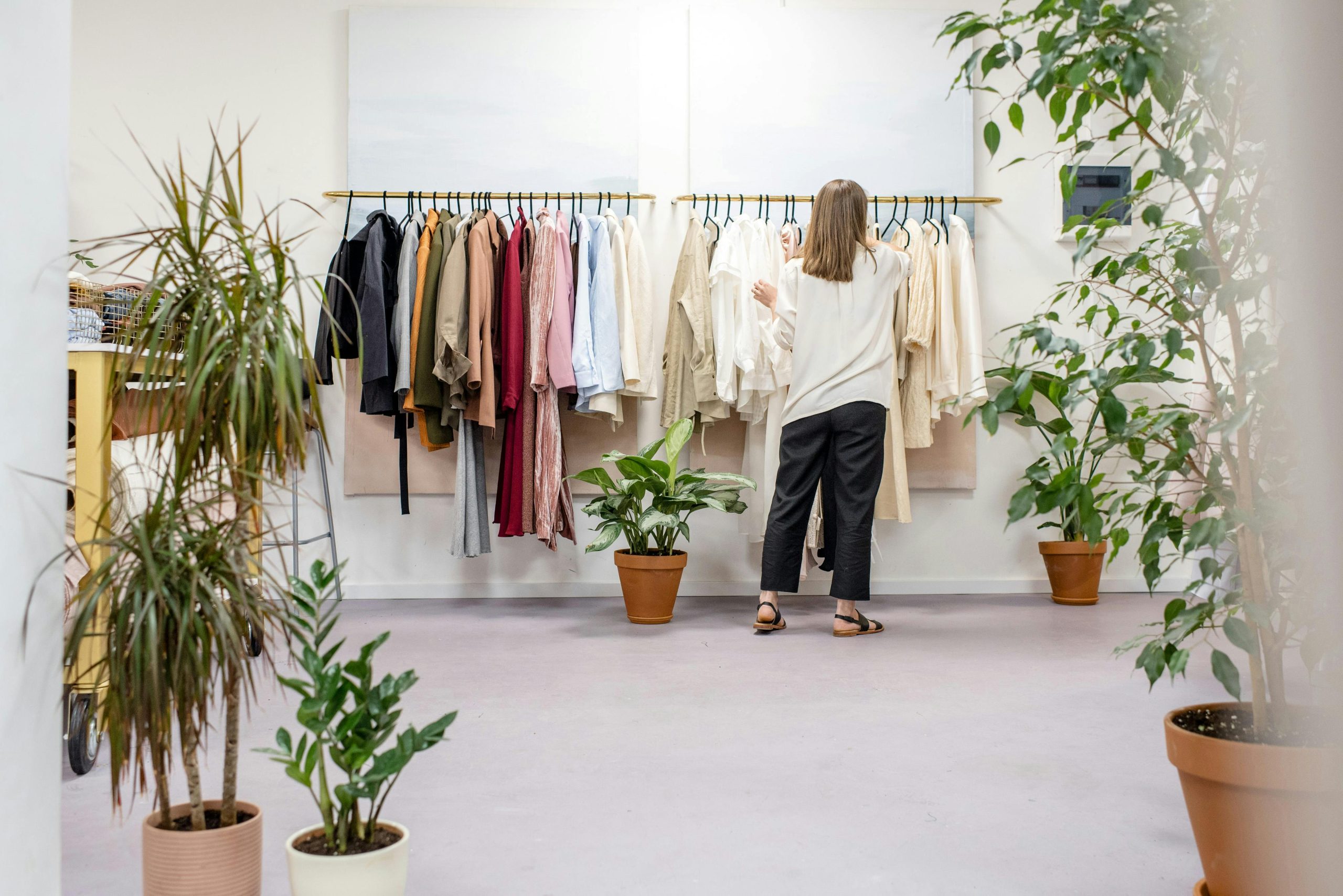 Store assistant arranging clothes on rack at fashion store